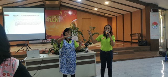 Para pemberi materi dari tim dekorasi paroki sedang memperagakan cara merangkai daun palma==